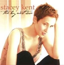 KENT STACEY :  THE BOY NEXT DOOR  (PURE PLEASURE)

Lo stile unico e distintivo di Stacey Kent potrebbe essere descritto come classico chic e potrebbe essere l'equivalente musicale del tubino nero: proprio come il tubino nero ha il potere di far trasparire la personalit� di una donna, le interpretazioni delicatamente sfumate di Stacey Kent del Great American Songbook mettono in risalto in modo eloquente le complesse melodie dei testi eleganti e sofisticati della musica popolare americana. A livello vocale, in The Boy Next Door, la signora Kent ha dato il meglio di s� e tante sono le cose da ammirare in questo disco: il suo mezzo soprano dai toni morbidi con una scintillante cadenza jazz ed il vibrato traslucido, il suo innato senso dello swing ed il tempismo istintivo, le sue letture delle linee sottilmente sfumate e la squisita delicatezza del suo fraseggio. Maestra narratrice e comunicatrice, nelle sue interpretazioni Stacey Kent si avvale anche delle capacit� interpretative di una laureata in lettere comparative che la portano ad evitare il sentimentalismo logoro a favore di un lirismo romantico e piccante. The Boy Next Door, � un omaggio sincero ai suoi eroi musicali tra i quali troviamo i leggendari crooner Frank Sinatra e Dean Martin, il maestro ottantenne del jazz Dave Brubeck ed il cantante di cabaret Bobby Short. Il repertorio dell'elegante vocalista comprende, per la prima volta, anche brani non appartenenti all'American Songbook, come splendidi originali di cantautori pop come Burt Bacharach, Paul Simon e Carole King. Affiancata dal suo impeccabile quintetto jazz capace di una straordinaria fluidit� ritmica, con The Boy Next Door Stacey Kent regala all'ascoltatore un album di elegante e raffinata musica.